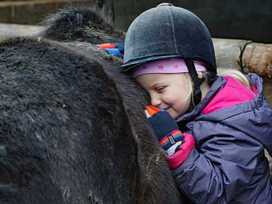 Kind beim Kuscheln mit einem Pony